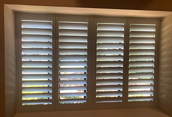 Plantation shutters enhancing the ambiance of a living room window in Tustin